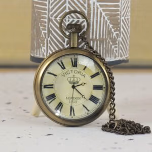 Antique brass 'Victoria London 1915' pocket watch with Roman numerals and a crown logo on the dial.