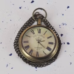 Angled close-up of the vintage-style pocket watch, highlighting the antique finish on the brass case and chain.