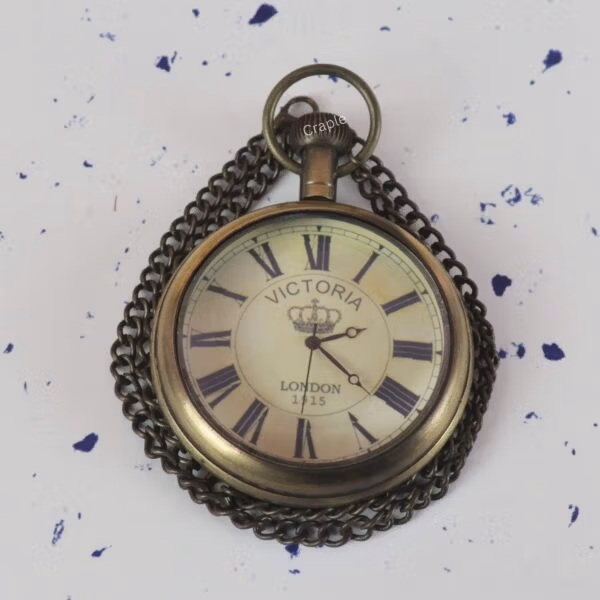 Angled close-up of the vintage-style pocket watch, highlighting the antique finish on the brass case and chain.