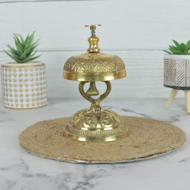 Vintage handcrafted brass call bell with an engraved top and ornate stand, for hotel or reception desk decor.