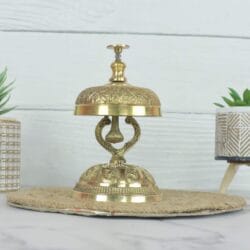 Side view of the vintage brass service bell, showcasing its ornate stand and polished golden finish.