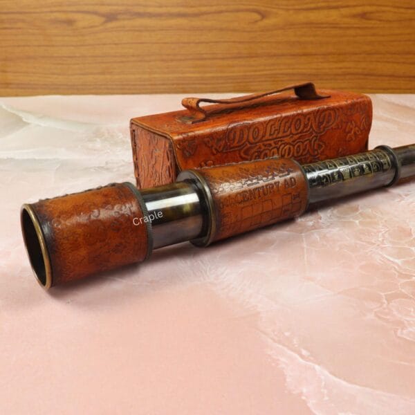 Collapsible antique-style spyglass with an etched brass barrel and leather wrap, shown with its protective leather box.