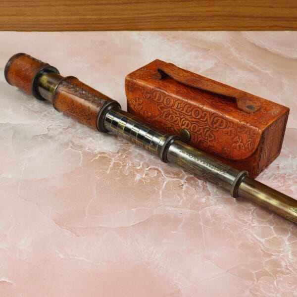 Antique-style collectible telescope with etched brass and a leather grip, shown partially collapsed.