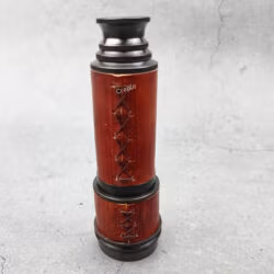 Close-up of the collapsed pirate-style telescope, showing the detailed cross-stitching on the red leather.