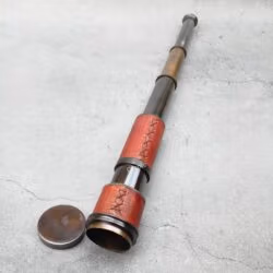 The fully extended 15.75-inch nautical spyglass showing its antique brass barrels and red leather grip.