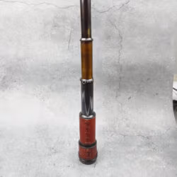 The vintage brass telescope standing flat at its full extension, showcasing all its collapsible sections.