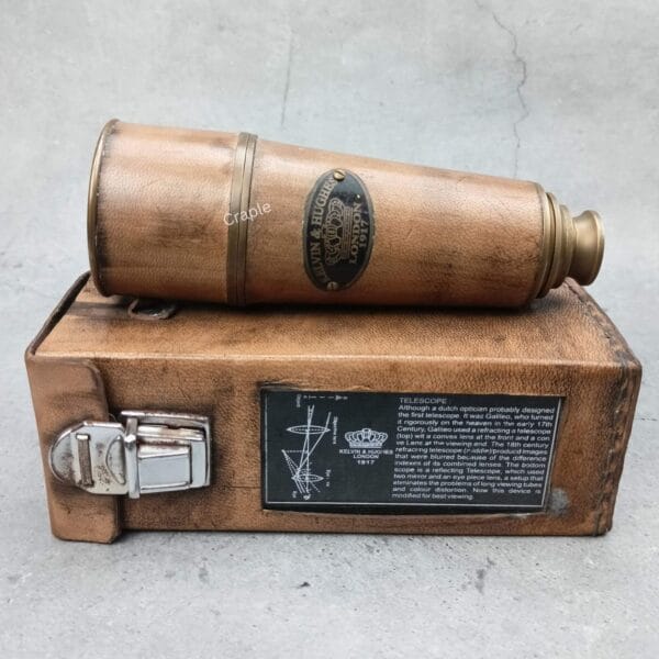 Vintage Kelvin & Hughes brass telescope in collapsed form, resting on its brown leather carrying case.