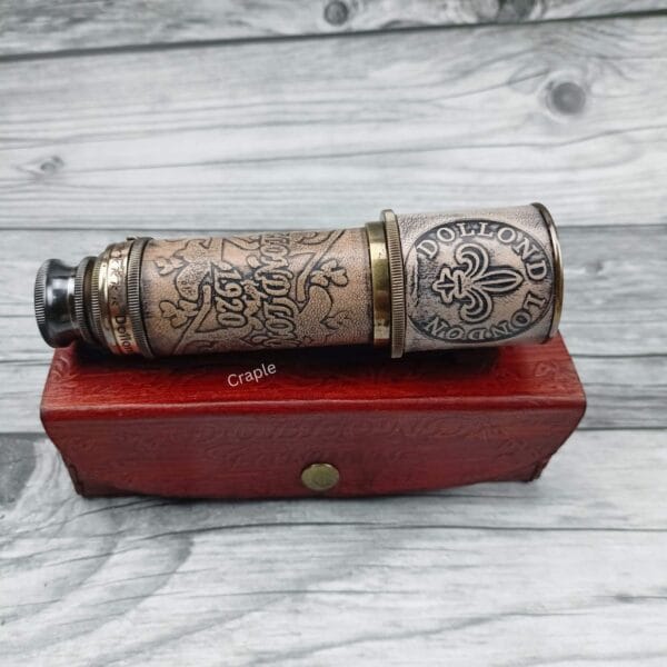 Close-up of the antique brass and embossed leather detail on the barrel of the Dollond London spyglass.