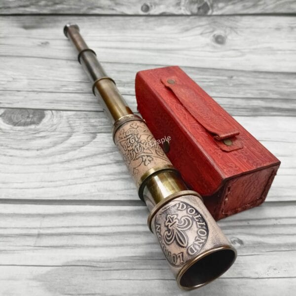 Antique brass Dollond London telescope with an embossed leather grip, partially extended next to its red leather case.