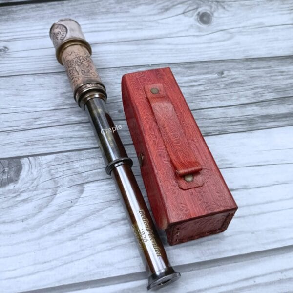 A top-down view of the Dollond London spyglass fully extended alongside its red leather storage box.