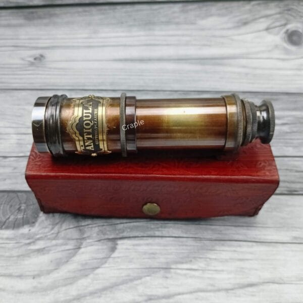 Antique brass Royal Navy telescope fully collapsed and resting on its handcrafted red leather storage box.