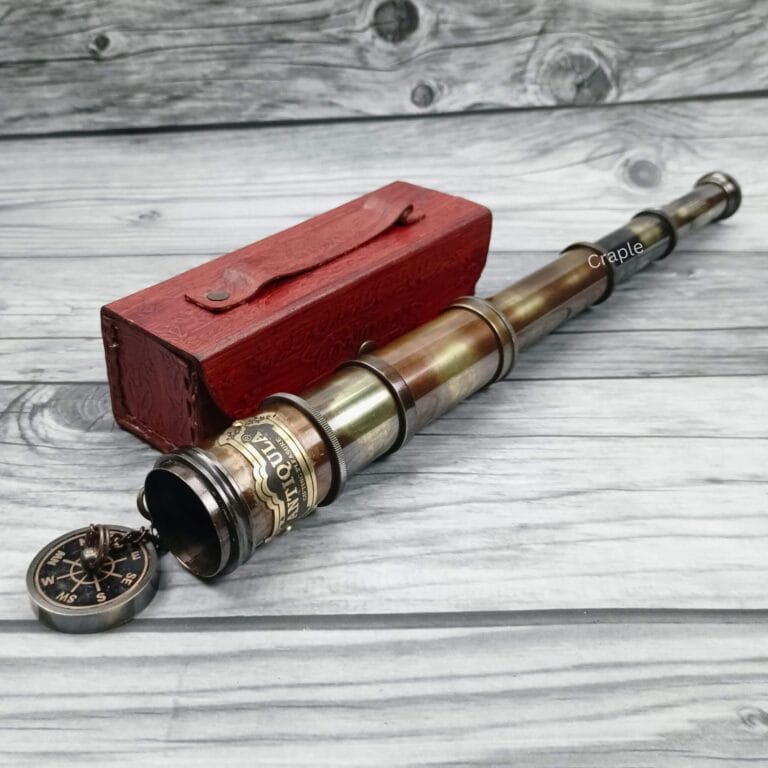 Antique brass Royal Navy telescope fully extended, with its eyepiece lens cap removed, displayed next to a handcrafted red leather box.