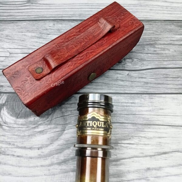 Detailed close-up of the main barrel of the brass spyglass, highlighting the decorative "Antiquarian" label.