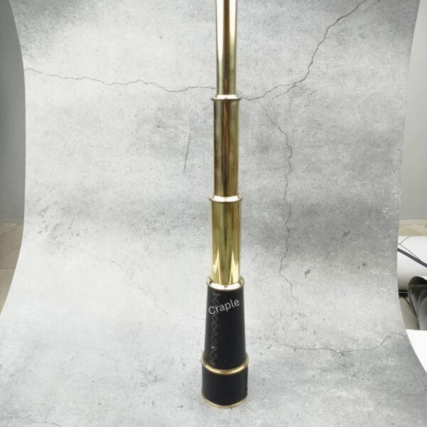 A fully extended 18.3-inch brass and leather pirate-style spyglass standing vertically.