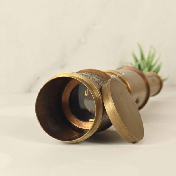 Close-up of the objective lens of the brass Victorian telescope, with the protective solid brass lens cap open.