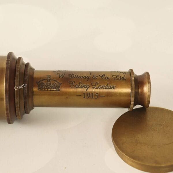 Close-up of the eyepiece on the antique brass telescope showing the 'W. Ottway & Co. Ltd, London 1915' engraving.