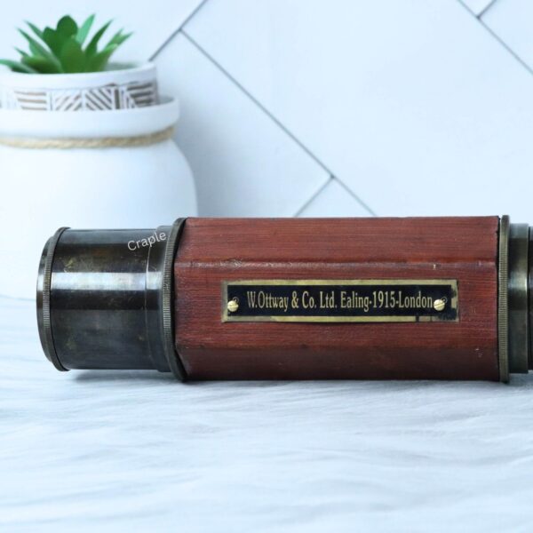 Close-up of the antique brass and leather-wrapped telescope, showing the "W. Ottway & Co. 1915 London" plaque.