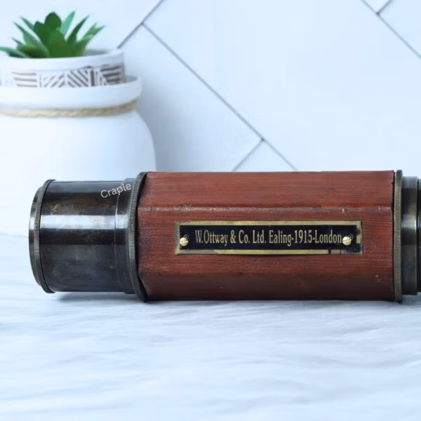 Close-up of the antique brass and leather-wrapped telescope, showing the "W. Ottway & Co. 1915 London" plaque.