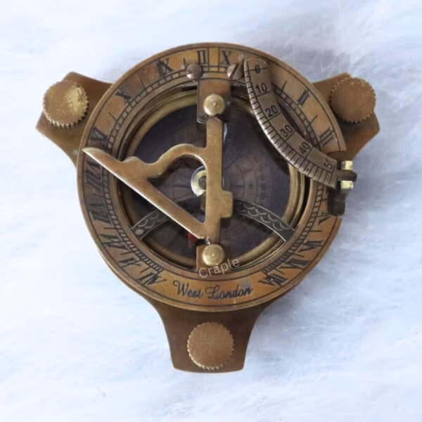 Top-down view of an antique brass sundial compass featuring a detailed face with Roman numerals.