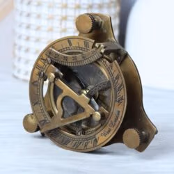 Side profile of the vintage brass sundial compass, showing the adjustable leg screws and antique finish.