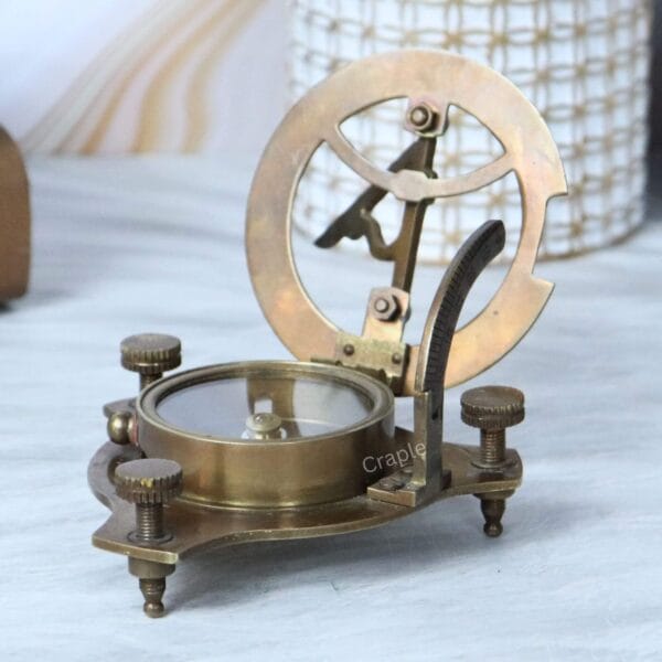 Side view of the brass sundial compass with its latitude arc and gnomon fully raised and open.