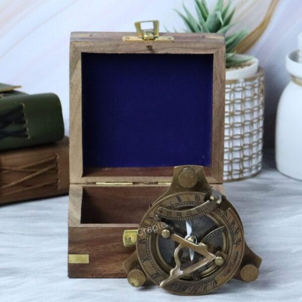 The antique brass sundial compass displayed next to its handsome sheesham wood gift box with blue velvet lining.