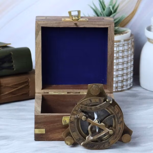 The antique brass sundial compass displayed next to its handsome sheesham wood gift box with blue velvet lining.