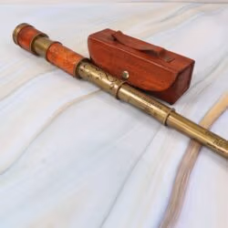 Antique-style brass and leather telescope, fully extended, lying next to its handcrafted wooden and leather storage case.