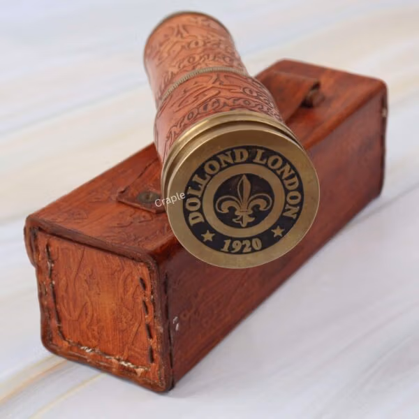 The compact, collapsed brass telescope with its leather grip, shown next to the vintage-style stitched leather case.