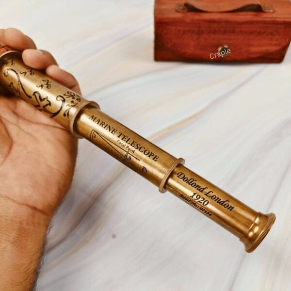 The fully extended brass and leather telescope being held to demonstrate its full length and impressive size.