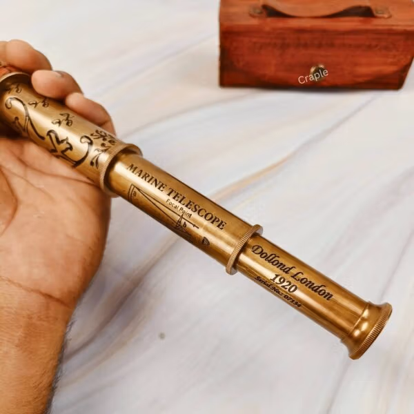 The fully extended brass and leather telescope being held to demonstrate its full length and impressive size.