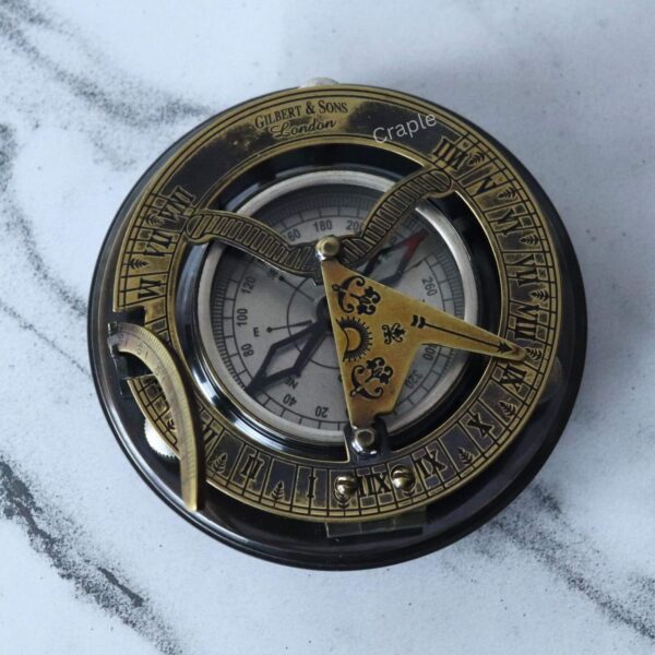Antique Brass-Silver Sundial Compass-1 Top-down view of an antique sundial compass featuring a brass Roman numeral ring and a silver-colored compass face.