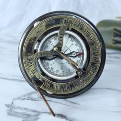 Antique brass and silver sundial compass with a foldable gnomon, displayed as a vintage decorative piece.