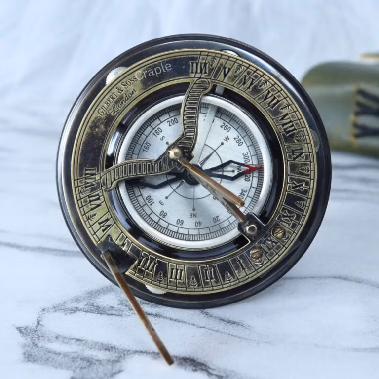 Antique brass and silver sundial compass with a foldable gnomon, displayed as a vintage decorative piece.