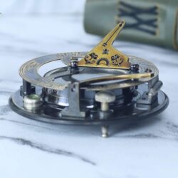 Side profile of the antique sundial compass with its brass gnomon raised into the upright position.