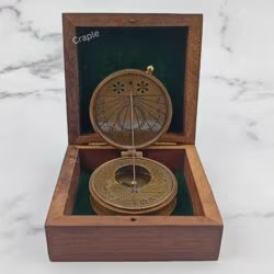Antique brass string sundial compass displayed open inside its green felt-lined wooden gift box.