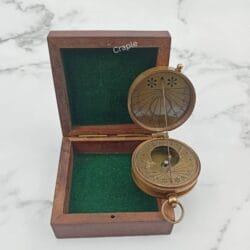 Vintage-style string sundial compass with an antique brass finish, shown open next to its wooden case.
