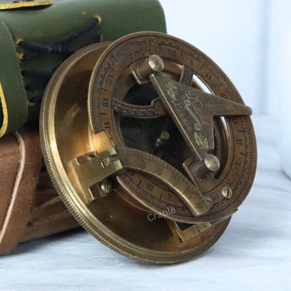 Angled perspective of the open brass sundial compass, highlighting its antique finish and intricate details.