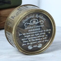 Side profile of the antique brass pocket sundial compass, displaying the detailed calendar and month markings.