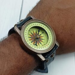 Angled view of the steampunk compass on a wrist, showing how the brass case sits on the leather band.