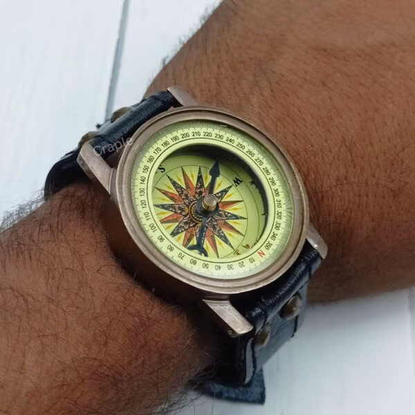 Angled view of the steampunk compass on a wrist, showing how the brass case sits on the leather band.