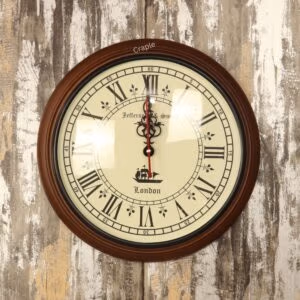 Vintage-style round wall clock with a dark brown wooden frame, an antique-white face, and classic Roman numerals.