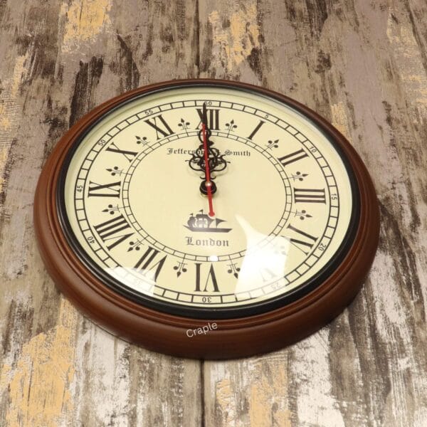 Close-up of the antique clock face, detailing the ornate black hands, Roman numerals, and London ship illustration.