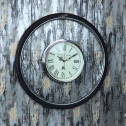 Unique wall clock made from a bicycle wheel, featuring a vintage-style clock face with Roman numerals inside the steel spokes.