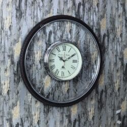 Close-up of a decorative wall clock with a rubber tire frame and steel bicycle spokes.