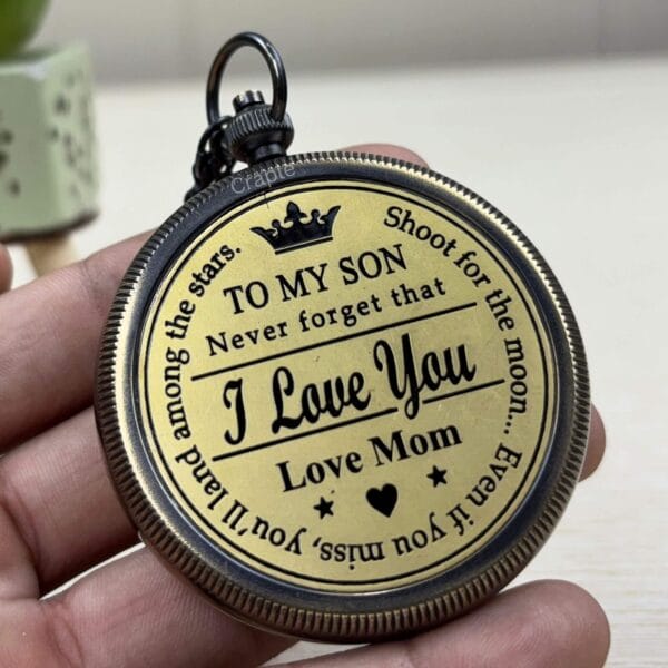 The back of the brass pocket compass showing the engraved message "TO MY SON... I Love You, Love Mom".