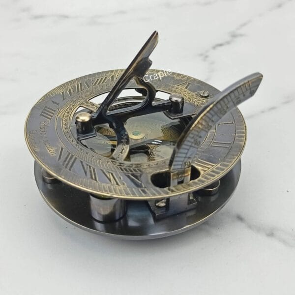 Side view of the black antique brass sundial with its triangular gnomon raised, ready for time-telling.