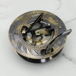 Antique brass sundial compass with a black finish, featuring a detailed sundial face with Roman numerals and an internal compass.