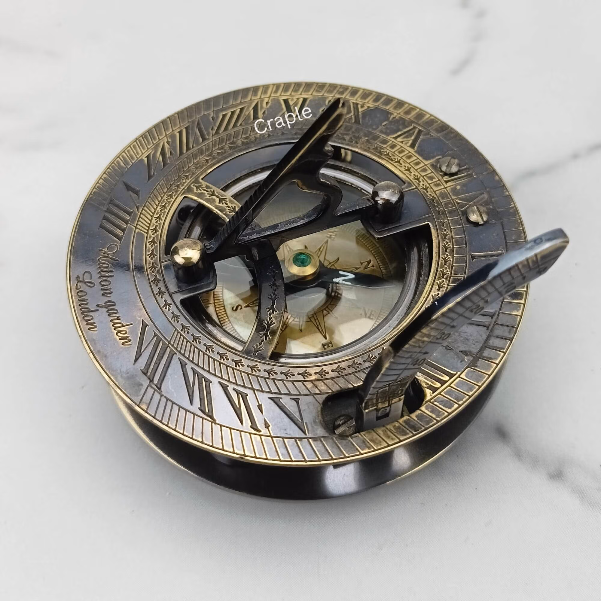 Antique brass sundial compass with a black finish, featuring a detailed sundial face with Roman numerals and an internal compass.