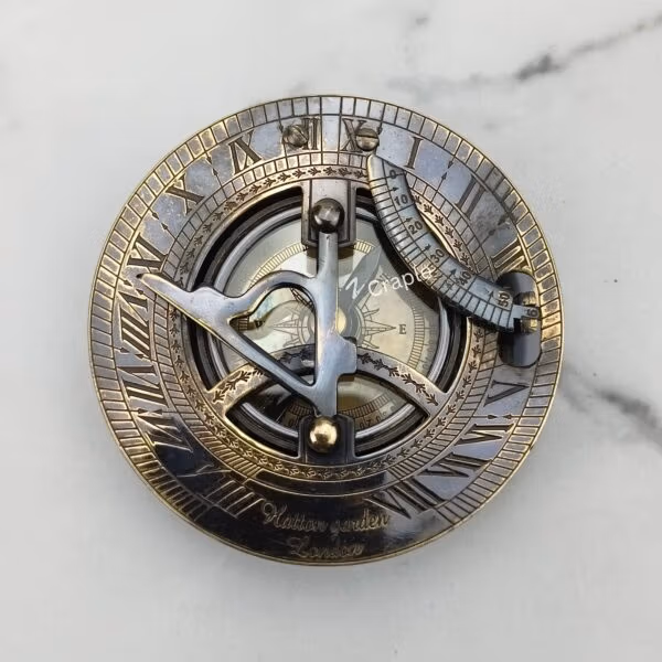 Top-down view of the black antique sundial compass face, detailing the gnomon, latitude arc, and Roman numerals.